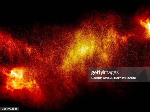 full frame of a jet of flammable liquid particles on fire on a black background. - flame texture stock pictures, royalty-free photos & images