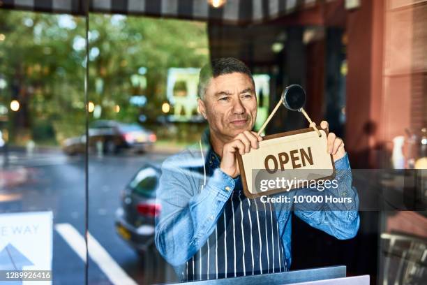 small business owner opening restaurant - restaurateur photos et images de collection