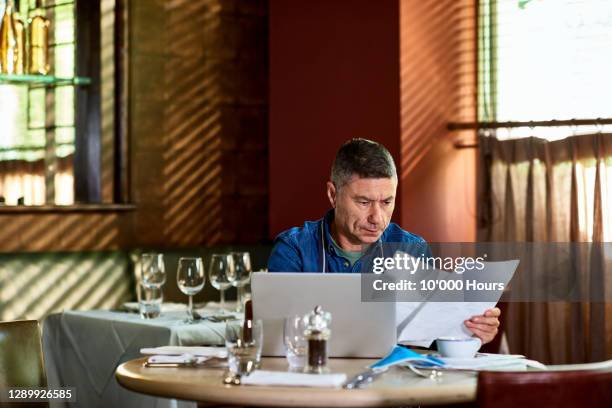 restaurant owner reading documents during pandemic - strategy stock pictures, royalty-free photos & images