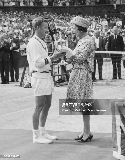 Rod Laver of Australia is presented with the Gentlemen's Singles Trophy by Princess Marina the Duchess of Kent after defeating Chuck McKinley of the...