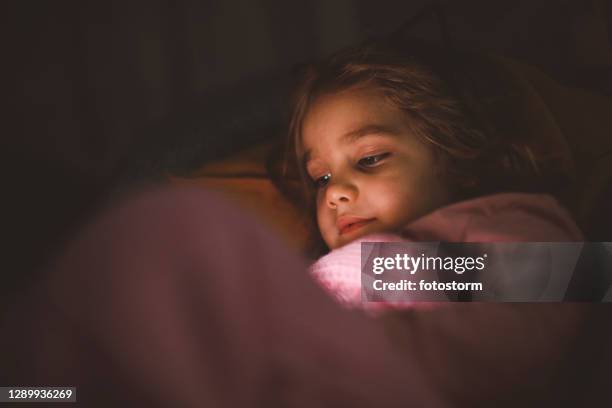 ver dibujos animados en el teléfono inteligente antes de dormirse en la cama - falling 2020 film fotografías e imágenes de stock