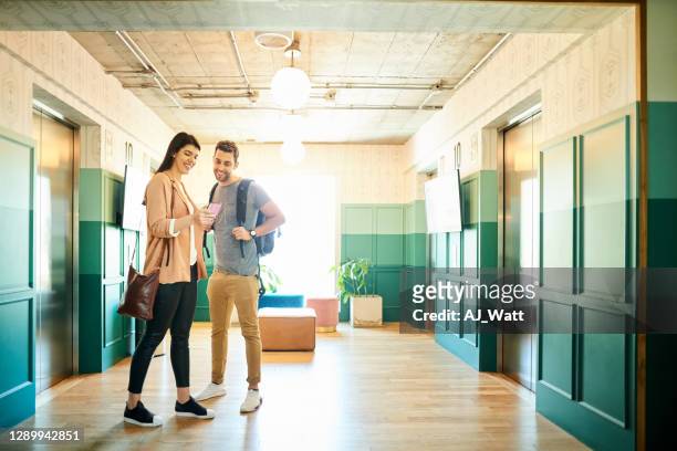 couple using phone while waiting for elevator - the lift presented stock pictures, royalty-free photos & images