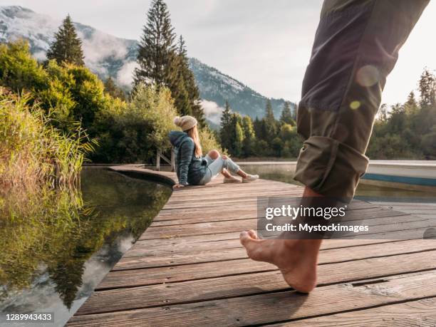 paar zu fuß entlang holzsteg am morgen - barefoot men stock-fotos und bilder