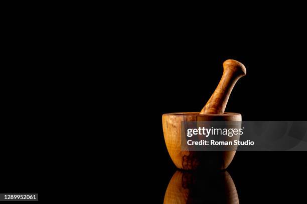 olive wooden mortar and pestle on black background with reflection - mortar and pestle stock pictures, royalty-free photos & images