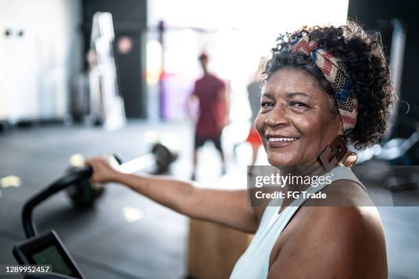 portrait of senior woman doing exercise in a gym - gym determination stock pictures, royalty-free photos & images