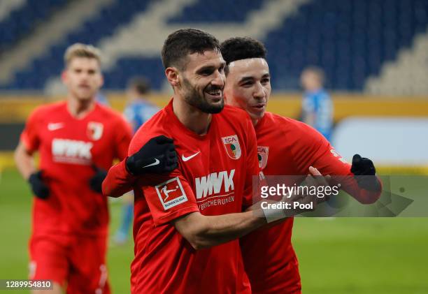 Daniel Caligiuri of Augsburg celebrates his team's first goal with teammate Ruben Vargas during the Bundesliga match between TSG Hoffenheim and FC...