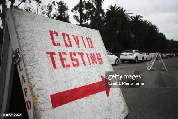 Vehicles line up to enter a COVID-19 testing site at Dodger Stadium on the first day of new stay-at-home orders on December 7, 2020 in Los Angeles,...