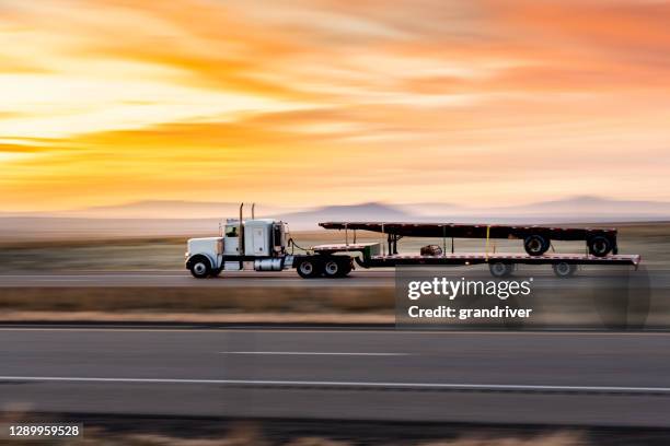 weißer sattelauflieger flatbedtruck auf einer vierspurigen autobahn bei dusk - lkw reifen stock-fotos und bilder