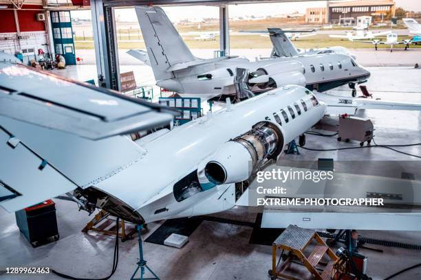 jet privati per la manutenzione visti nell'hangar - hanger foto e immagini stock