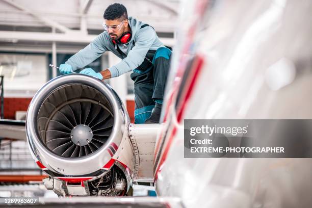 ジェットエンジンの上で働く航空機整備士 - aerospace engineer ストックフォトと画像