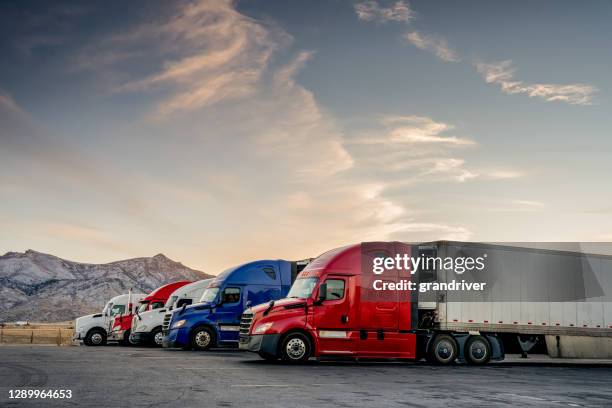 rot-weiß-blau geparkte lastwagen an einer lkw-haltestelle aufgereiht - truck highway stock-fotos und bilder