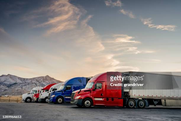 caminhões vermelhos brancos e azuis estacionados alinhados em uma parada de caminhões - caminhão - fotografias e filmes do acervo