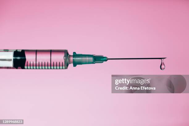 syringe with drop of medicine - spritze stock-fotos und bilder