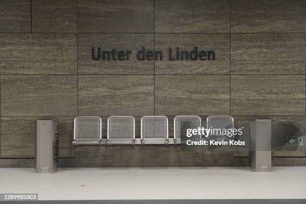 subway sign of the station "unter den linden" with a bench in berlin, germany. - berlin subway stock pictures, royalty-free photos & images