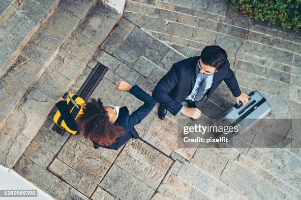 colleagues meet outdoors and greet with an elbow bump - business travel mask stock pictures, royalty-free photos & images