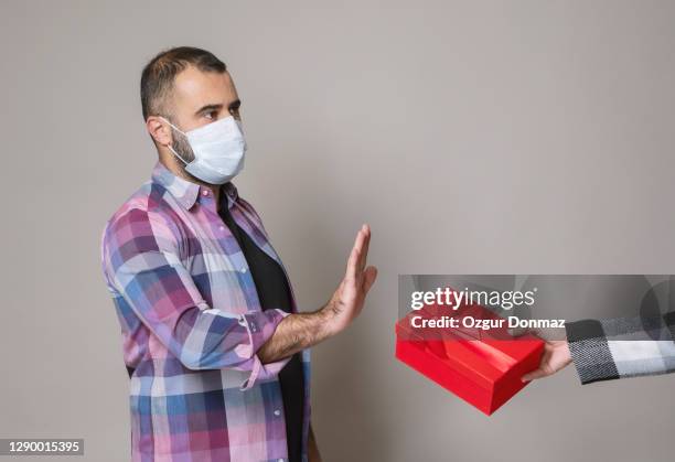 man refuse to take christmas present during covid-19 pandemic - unwanted present stock pictures, royalty-free photos & images