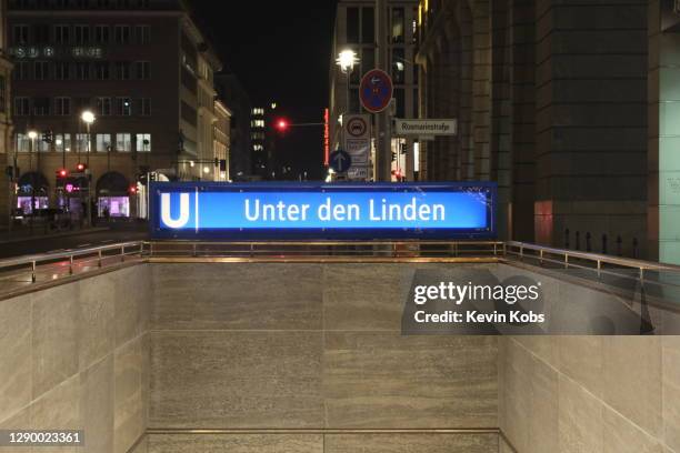 subway entrance with sign of the station "unter den linden" in berlin, germany. - entrance sign stock-fotos und bilder