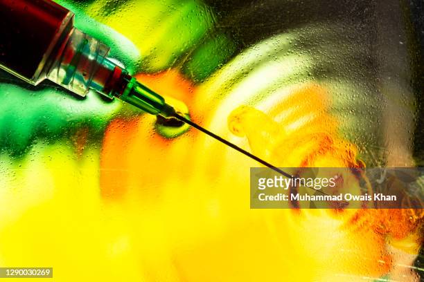 vaccine syringe - colourful studio shots stock-fotos und bilder