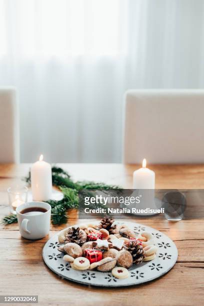 plate of advent cookies with cup of tea and candles on wooden table. white curtains background. - natalia star stock pictures, royalty-free photos & images