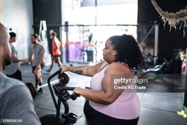 young woman exercising in the gym - fat man riding bike stock pictures, royalty-free photos & images