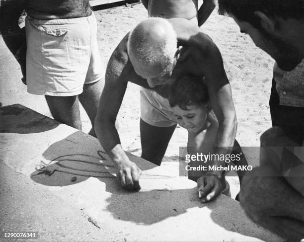 Picasso apprenant à dessiner à son fils Claude une Colombe de la Paix sur la plage du Golfe-Juan.