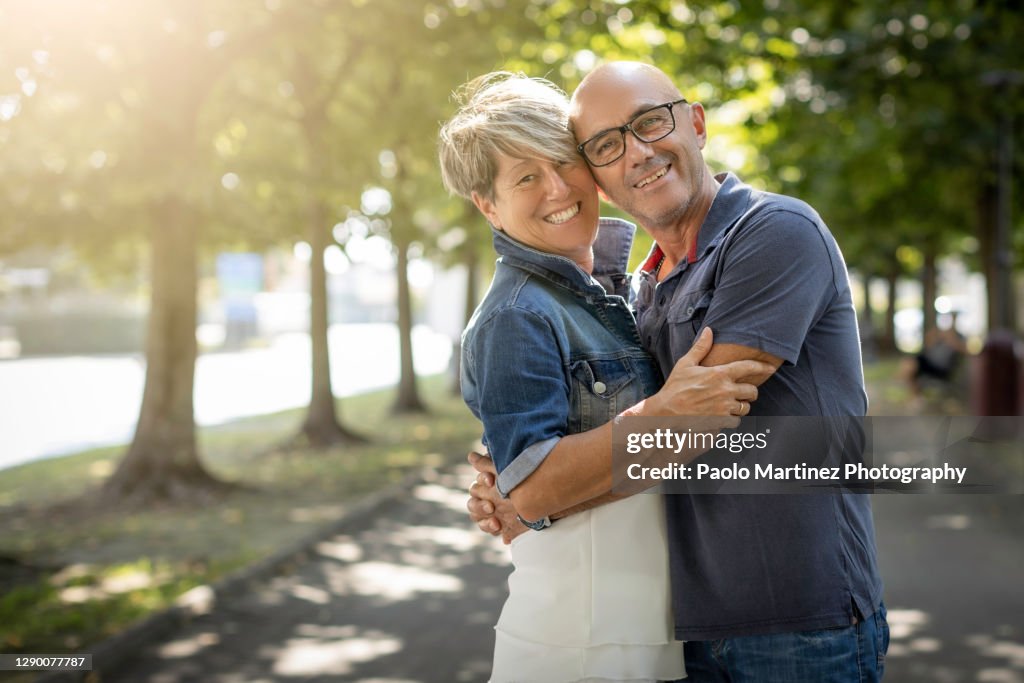 Happy mature couple standing and smiling in a park