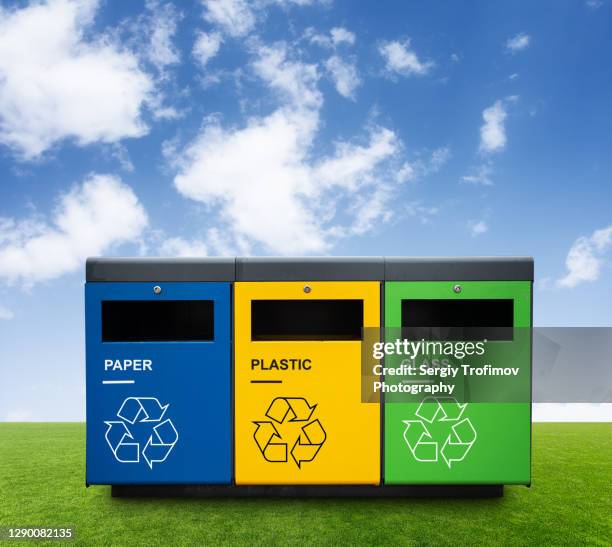 recycling bins on green grass with blue sky on background - recycling bin fotografías e imágenes de stock