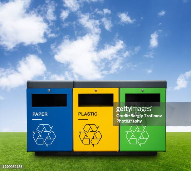 recycling bins on green grass with blue sky on background - bottle bank stock pictures, royalty-free photos & images