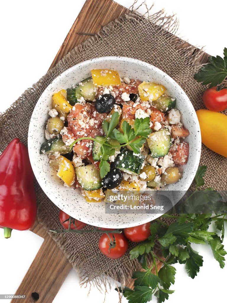 Food photography of diet vegetarian dish, vegetable salad with soft cheese and parsley  top view in a rustic style on a white background isolated close up