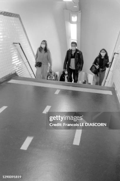 Voyageurs masqués dans un couloir de la station de métro "Place de Clichy", flèches au sol indiquant les sens de déplacement, en septembre 2020,...