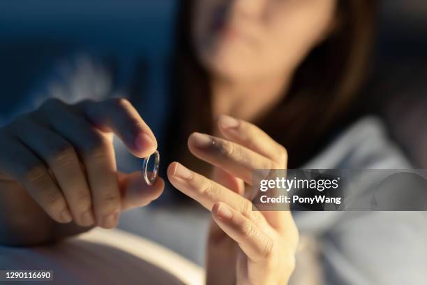 de gedeprimeerde vrouw houdt huwelijksring - affairs stockfoto's en -beelden