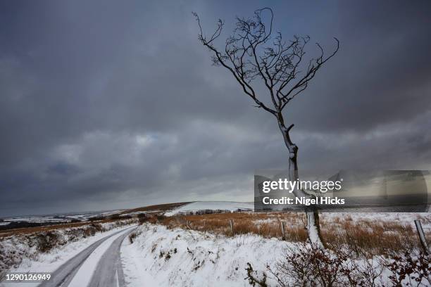 a country road in snowy, wintery weather on the hills of exmoor national park, in devon, great britain. - exmoor winter stock pictures, royalty-free photos & images
