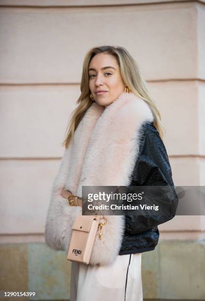 Sonia Lyson is seen wearing total look Fendi Holiday Collection, rose faux fur scarf, belted Fendi bag, jacket with Fendi print, wide leg pants on...