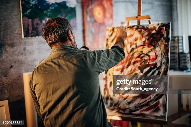 male artist painting in his art studio - painter artist stock pictures, royalty-free photos & images
