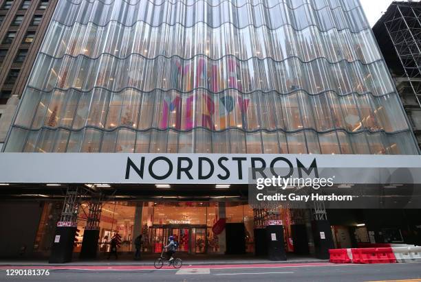 Person rides past the Nordstrom department store decorated for Christmas on 57th Street on December 8, 2020 in New York City.