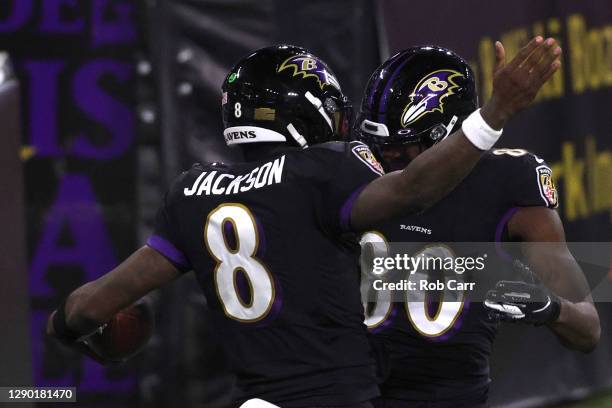 Quarterback Lamar Jackson of the Baltimore Ravens celebrates with teammates after rushing for a touchdown against the Dallas Cowboys during the first...