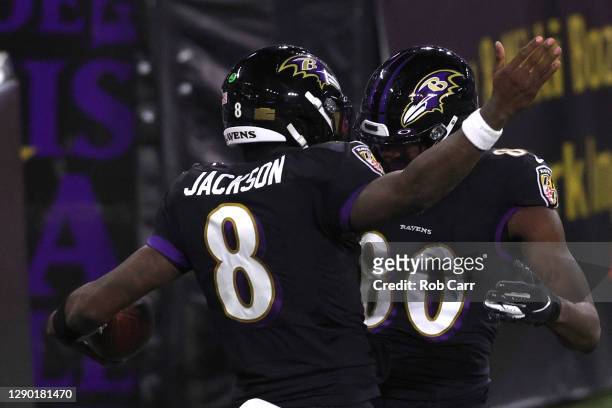 Quarterback Lamar Jackson of the Baltimore Ravens celebrates with teammates after rushing for a touchdown against the Dallas Cowboys during the first...