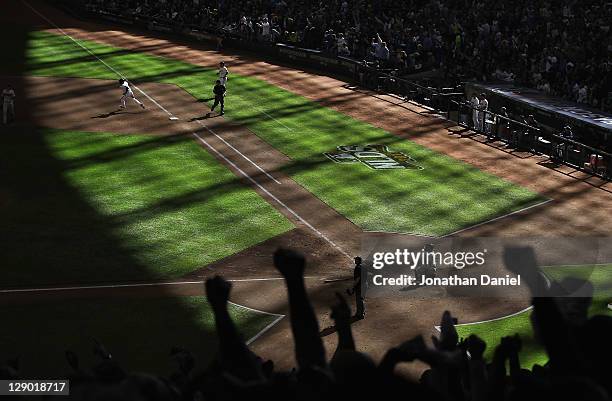 Fans cheer as Yuniesky Betancourt of the Milwaukee Brewers runs the bases after hitting a triple against the Arizona Diamondbacks during Game One of...