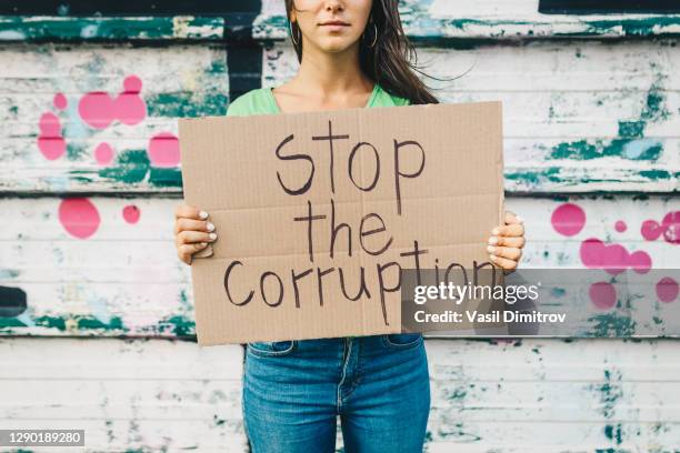 young woman holding a poster against corruption. human rights and democracy concept. young activists concept. - woman collapsing stock pictures, royalty-free photos & images