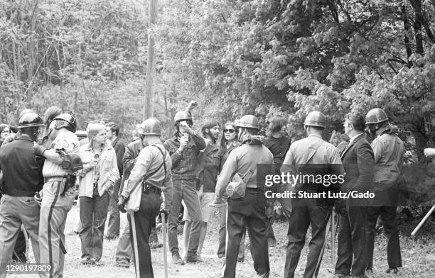 Helmeted State Police carrying long batons, from the back, defend a forested border during anti-Vietnam War protests at Fort Dix, New Jersey, May 16,...