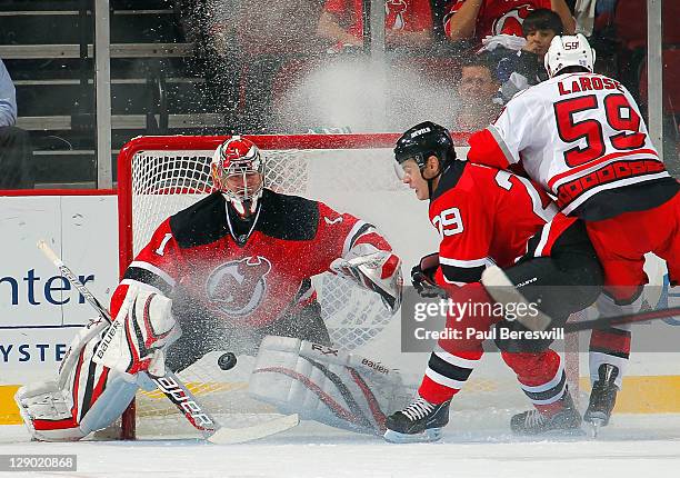 Goalie Johan Hedberg of the New Jersey Devils stops a shot by Chad LaRose of the Carolina Hurricanes during the second period of an NHL hockey game...