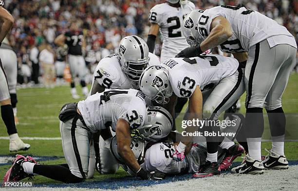 Safety Michael Huff of the Oakland Raiders is mobbed by his teammates after intercepting a pass on the goalline intended for wide receiver Jacoby...