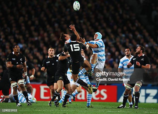 Mils Muliaina of the All Blacks goes up for a high ball with Leonardo Senatore and Gonzalo Camacho of Argentina during quarter final four of the 2011...