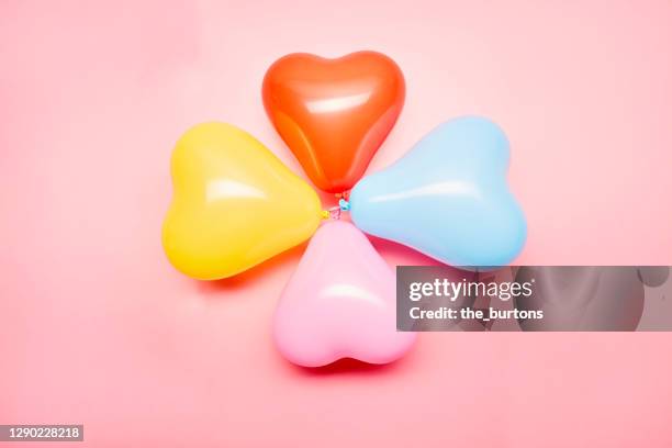 high angle view of colourful balloons in heart shape on pink background - 幸運 ストックフォトと画像