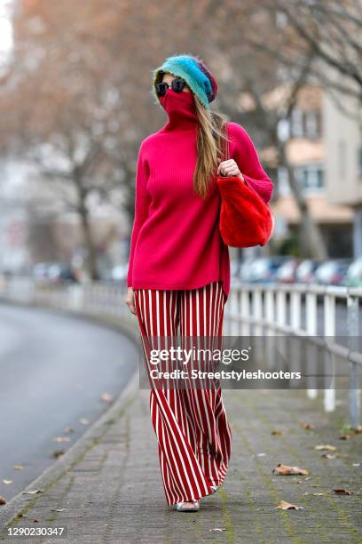 German actress Alexandra Kamp wearing red and white striped flared pants by Top Shop, a pink turtleneck pullover by Amorph, a vintage blue green and...