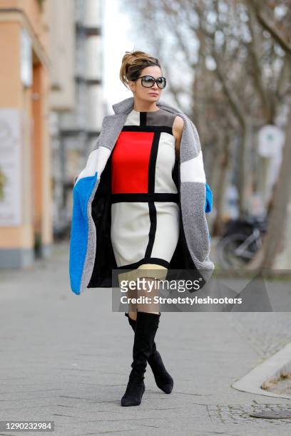 German actress Alexandra Kamp wearing black knee high boots by Salvatore Ferragamo, a blue white and light grey teddy coat by Silvian Heach,...