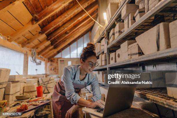female entrepreneur in her pottery sculpting studio - art-studio-computer stock pictures, royalty-free photos & images