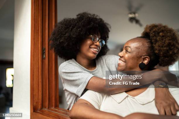 happy mother and daughter embracing - african girl hug stock pictures, royalty-free photos & images