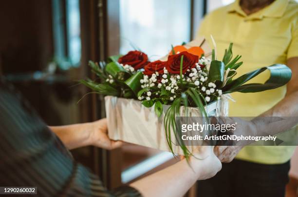 woman receive flower bouquet from delivery person. - receiving flowers stock pictures, royalty-free photos & images