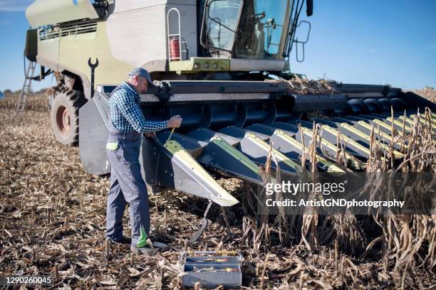 mekaniker reparera trasiga kombinera maskin inom jordbruk området. - agricultural equipment bildbanksfoton och bilder